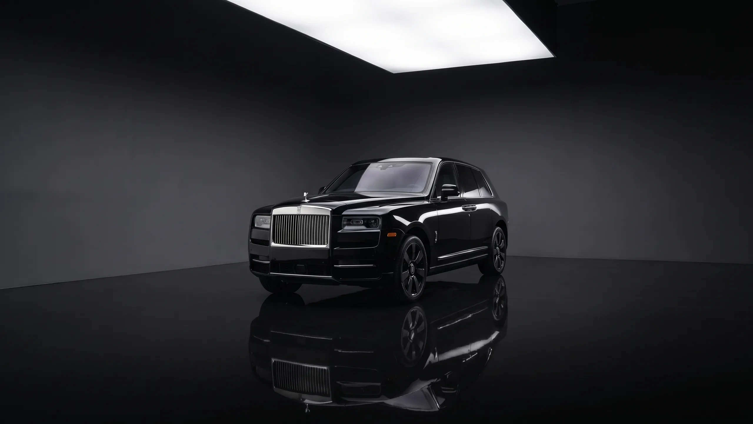 Black Rolls-Royce Cullinan with hand-polished silver grille in the Seven Star showroom, reflected in the polished black floor — the signature wedding chauffeur SUV in Vancouver